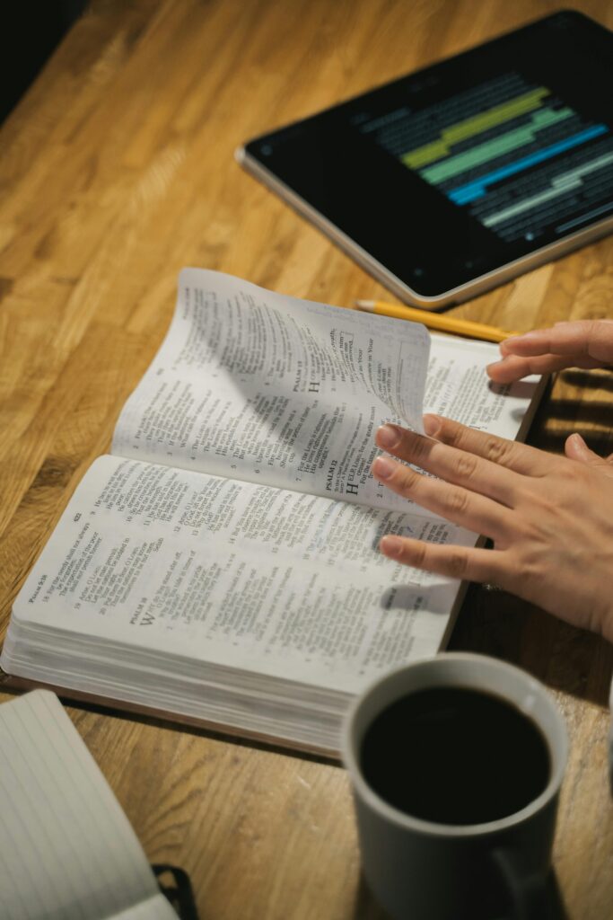 open Bible fingers turning pages